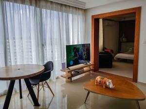 アビジャンにあるAppartements Lamblinのリビングルーム(テーブル、薄型テレビ付)