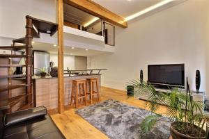 a living room with a kitchen and a loft at TOULOUSE DUPLEX PLACE DU CAPITOLE in Toulouse