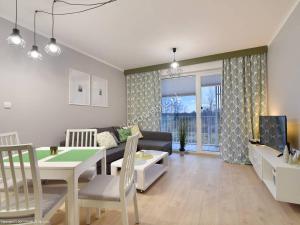 a living room with a couch and a dining room at Apartamenty Familijne- Os Feniks in Kołobrzeg