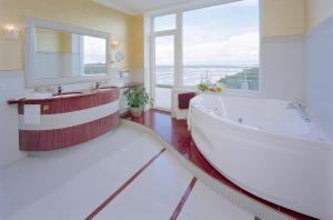 a bathroom with a large tub and a large window at Baltic Beach Hotel & SPA in Jūrmala