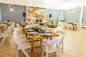 a dining room with wooden tables and white chairs at Loskop Valley Lodge in Groblersdal