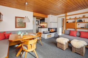 a living room with a table and a couch at DAS HAUS IM WALD in Seefeld in Tirol