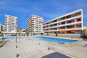 una piscina frente a dos edificios altos en La Nogalera Deluxe Apartment Torremolinos, en Torremolinos