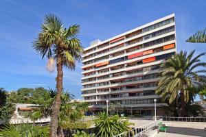 un edificio alto con palmeras delante en La Nogalera Deluxe Apartment Torremolinos, en Torremolinos