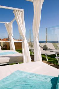 two beds on a deck with a view of the ocean at Hotel Ereza Mar - Adults Only in Caleta De Fuste