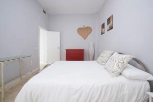 una camera bianca con un letto bianco e un comò rosso di AlohaMundi Lumbreras I a Siviglia