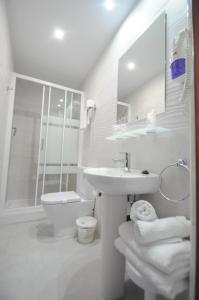 a white bathroom with a sink and a toilet at Hotel Goya in Almuñécar
