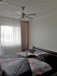 a bedroom with a bed with a ceiling fan at 60 qm mit Aussicht in Konz in Konz