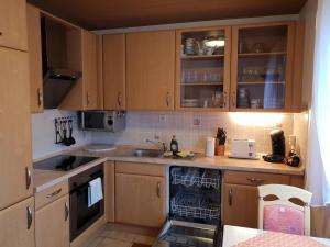 una pequeña cocina con armarios de madera y fregadero en 60 qm mit Aussicht in Konz, en Konz