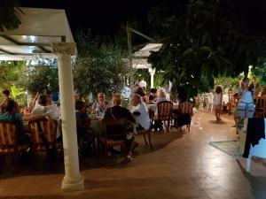 un grupo de personas sentadas en mesas en un restaurante en Federico Re, en San Vito lo Capo