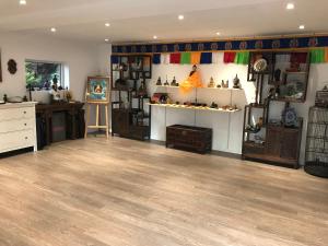 a room with wooden floors and shelves of items at La Bichurie in Feugères