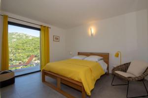a bedroom with a yellow bed and a balcony at Villa neuve architecte vue mer in Belvédère