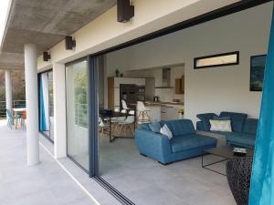 a living room with two blue couches and a kitchen at Villa neuve architecte vue mer in Belvédère