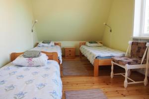 Pokój z 2 łóżkami pojedynczymi i krzesłem w obiekcie Männi Guesthouse w mieście Haapsalu