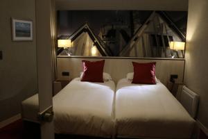 a hotel room with two beds and two lamps at Les Terrasses Poulard in Le Mont Saint Michel