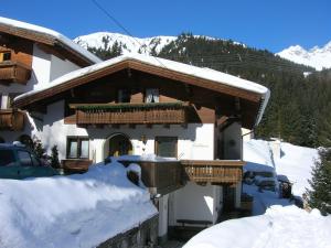 a snow covered house with a balcony in the snow at Apartment Valtiner in Sankt Anton am Arlberg