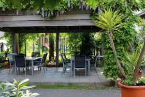 un patio con mesas, sillas y una palmera en Hotel Sunnegässle, en Rust