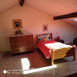 een slaapkamer met een bed en een houten dressoir bij mansarda mare bella vista CITRA zero zero ottanta trentuno LT O738 in Imperia