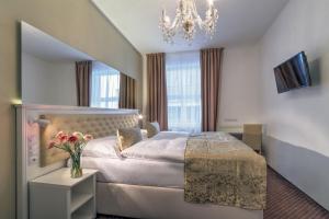 Habitación de hotel con cama y lámpara de araña. en Hotel Taurus, en Praga