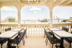 a porch with tables and chairs and a view of the ocean at Hotel Carducci 76 in Cattolica