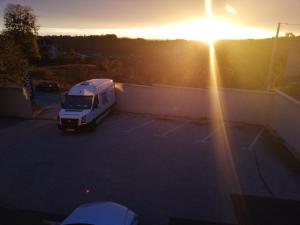 a white truck parked in a parking lot with the sunset at Prenoćište SAMIR in Gradačac