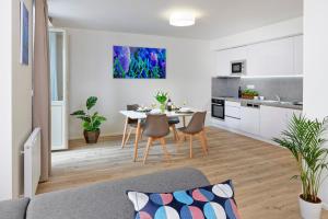 a kitchen and living room with a table and chairs at DownTown Suites Jugoslavska in Prague