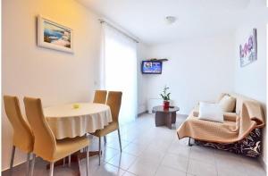 a living room with a table and chairs and a tv at Apartments Bonsai in Podstrana