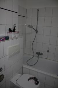 ein Bad mit einer Dusche, einem WC und einer Badewanne in der Unterkunft Andrea in Lübeck