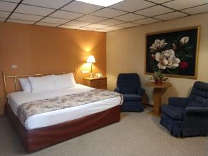 a hotel room with a bed and two blue chairs at Five Star Inn - Maggie Valley in Maggie Valley