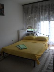 sypialnia z łóżkiem z żółtym kocem i oknem w obiekcie Đokić apartmani w mieście Sokobanja