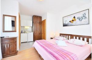 a bedroom with a large bed and a kitchen at Apartments Bonsai in Podstrana