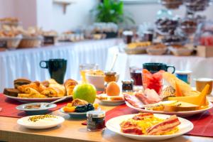 a table with plates of food on a table at Le Green des Impressionnistes in Ennery