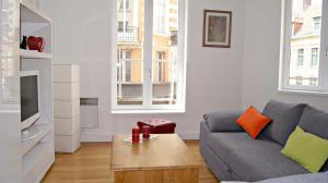 a living room with a couch and a coffee table at Little Suite - Théo in Lille