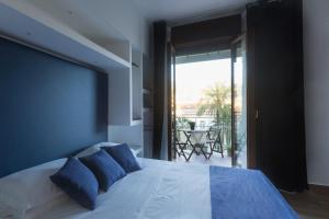 a bedroom with a bed with blue pillows and a balcony at Central Plaza Sorrento Coast in Sant'Agnello