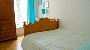 a bedroom with a bed with a wooden head board at Little Suite - Théo in Lille