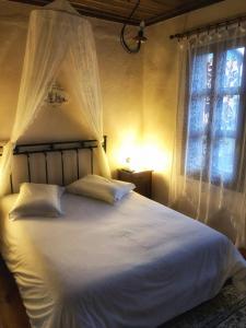 a bedroom with a large white bed with a window at Varosi Guesthouse in Edessa
