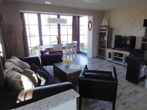 a living room with couches and a television and a table at Ferienhaus Seeraeuber in Vieregge