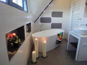 a bathroom with a tub and two candles in it at Ferienhaus Seeraeuber in Vieregge +24 photos