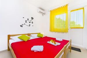 Schlafzimmer mit einem roten Bett und einem roten Tisch in der Unterkunft Apartments Pava in Okrug Donji