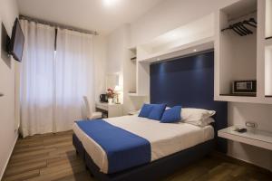 a bedroom with a large bed with a blue headboard at Central Plaza Sorrento Coast in Sant'Agnello +16 photos