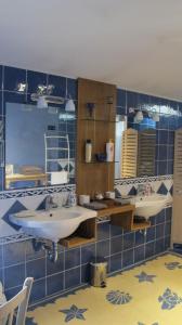 メルイユにあるDomaine de Valbrillantの青いタイル張りの壁、洗面台2台付きのバスルーム