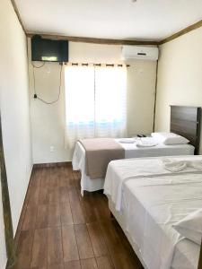 - une chambre avec 2 lits et une fenêtre dans l'établissement Pousada Café da Roça, à Campos Gerais