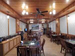 a restaurant with tables and chairs and a ceiling fan at Sitou Peach Villa B&B in Lugu Lake