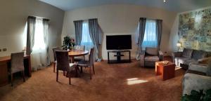 ein Wohnzimmer mit Sofa, Tisch und Fernseher in der Unterkunft Hotel Park Central in Sliven