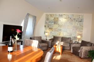ein Wohnzimmer mit Sofa, Tisch und Stühlen in der Unterkunft Hotel Park Central in Sliven