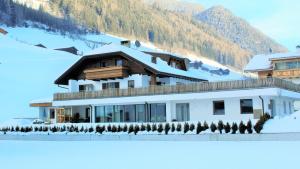 a house in the snow with a mountain at Apartment an der Aue in Cadipietra