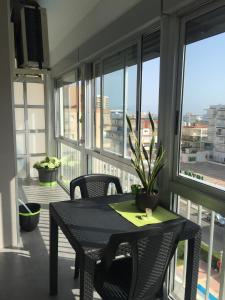 einen Balkon mit einem Tisch, Stühlen und Fenstern in der Unterkunft Apartamento Cantabria 23, 6-66 in Playa de Gandia