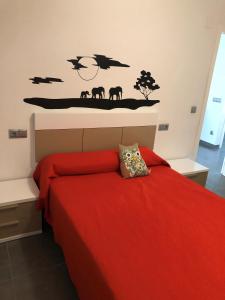 Schlafzimmer mit einem Bett mit einer roten Bettdecke in der Unterkunft Apartamento Cantabria 23, 6-66 in Playa de Gandia