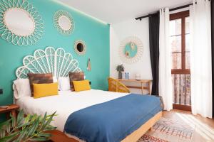a bedroom with a large bed with blue walls at Casa Vaganto in Barcelona