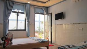 1 dormitorio con ducha, ventana y TV en Hong Chau Guesthouse, en Phu Quoc